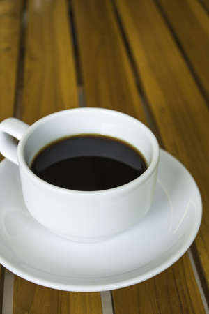 Cup of coffee on a wooden table verticleの写真素材