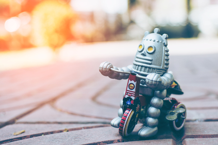 Retro robot toy on wood table, vintage color style, vintage tone background.の写真素材