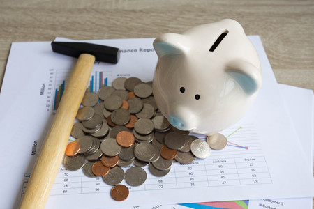 Piggy bank with hammer on wood table. business and finance concept.の写真素材