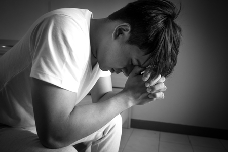 Asian man with sad mood in the room, sadness portrait concept, black and white tone.の写真素材