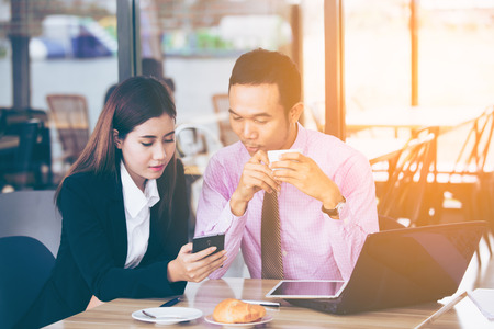 Asian business people, businesswoman and businessman use smartphone, Portrait business concept, vintage color tone.の写真素材