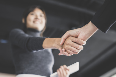 Asian businesspeople shaking hands greeting each other, vintage tone.の写真素材