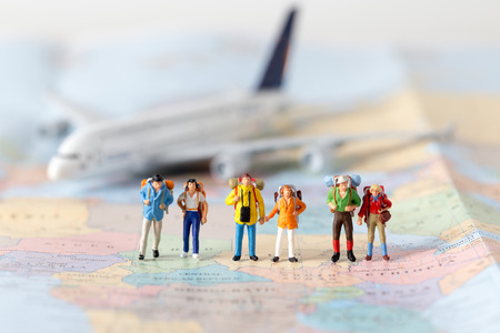 Miniature model team traveller model standing together on map, people travel in concept,