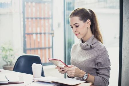 Young woman using tablet  in modern place. Business people with relaxing emotion at modern office. Greeting deal conceptの写真素材
