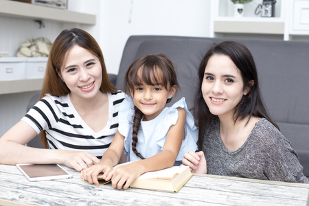 Happy family woman and kid reading book at home, happy family concept, 3 person