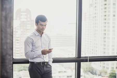 Business using smartphone for working at office place, man working concept, vintage tone.の写真素材