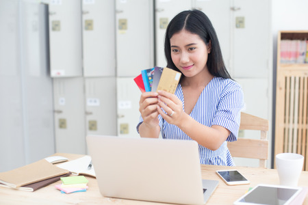 Beautiful asian women holding a lot of craditcard for shopping online with laptop, online shopping protrait concept.の写真素材