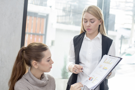 Young woman working together in modern place. Business people takling in modern office, 2 person.の写真素材