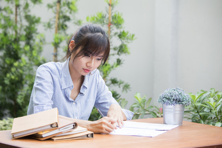 Young asian women writing homework on desk, woman working concept.の写真素材