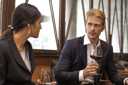 Businessman and Woman Talking for Business while Drinking red wine in Bar, People with Business concept.の写真素材