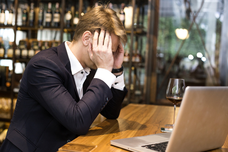 Businessman Hangover suffering when he drunk wine at Bat, Man with alcoholism concept.の写真素材
