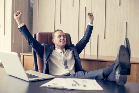 Businessman sitting with relax feeling at office, Man finishing up a work, Man with Leader Concept. Vintage tone.の写真素材