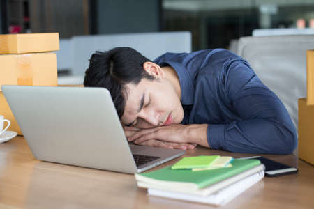 Businessman sleep while working at office, People working Overtime Conceptの写真素材