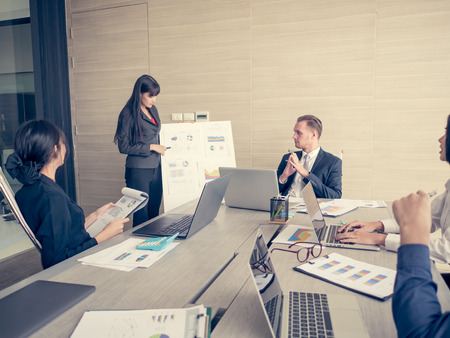 Asian Business Woman presenting her work with team at the meeting room, People working Concept. Vintage tone.の写真素材