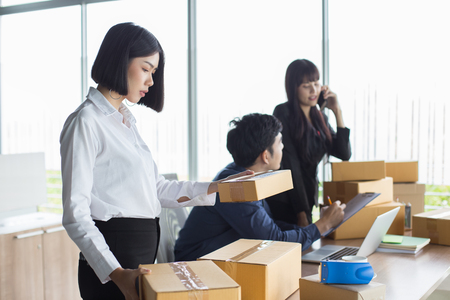 Young Asian Woman holding box and working at office, Young Owner Woman Start up for Business Online, SME, Delivery Project, Woman with Online Business or SME Concept.の写真素材