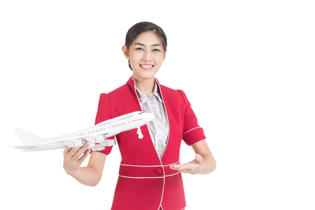Portrait of Asian Air Hostess holding airplane model and passport stand and smile isolated on white backgroundの写真素材