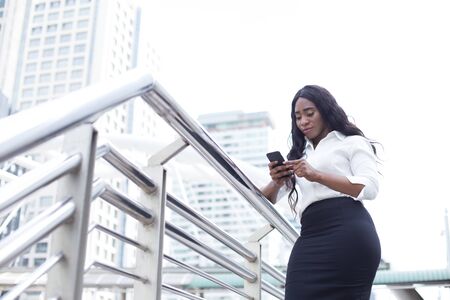 Young Beautiful Business Woman using smartphone in City. Young Business Woman have Confident for...