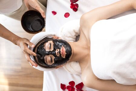 Two Young Beautiful Asian woman with charcoal mask in Spa salon, Spa, health and healing concept.の写真素材
