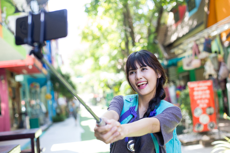 Portrait of Happy traveler Woman Selfie in city. Asian women using Smartphone for Selfie  with Happy emotions, Woman with Travel Concept.の写真素材