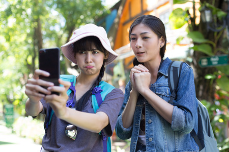 Portrait of Happy traveler Woman Selfie with friend together in city. Asian women using Smartphone with Happy emotions, Woman with Travel Concept.の写真素材