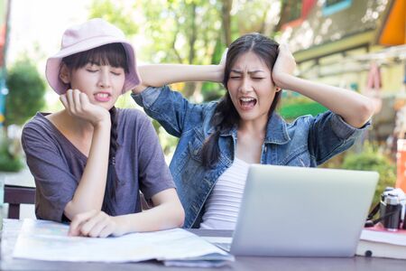 Portrait of Traveler Woman in city. Asian women using Map and Laptop for seach location, People with Traveler Concept.の写真素材