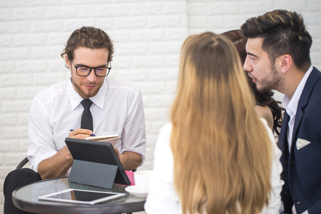 Businessman Sitting in office and Work with Team. Businessman writing Information for Meeting with Team. Businessman Working concept.の写真素材