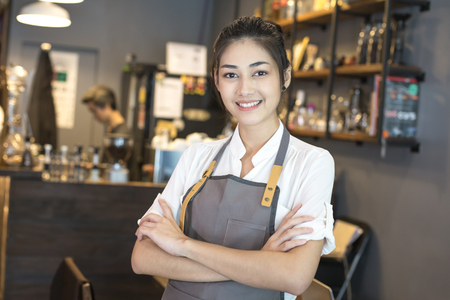Asian barista woman standing with attractive smiling at front of cafe. Woman success to make sme business.の写真素材