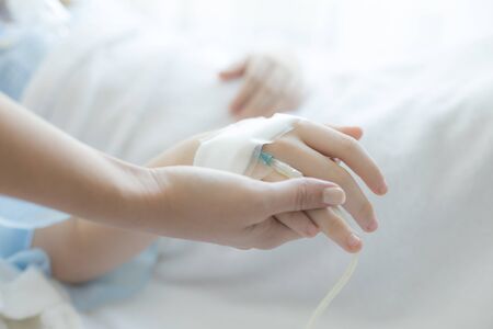 Woman holding children hand in hospital. girl sick in hospital. People with medical concept.の写真素材