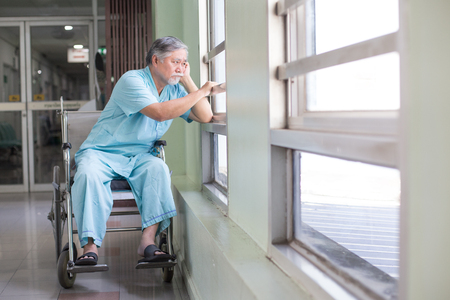 Asian old man sit on wheelchair looking out to other place. People with health care and medical concept.の写真素材
