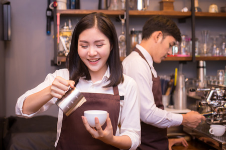 Asian female barista making coffee in coffee shop counter.  Barista female working at cafe. Woman working with small business owner or sme concept.の写真素材