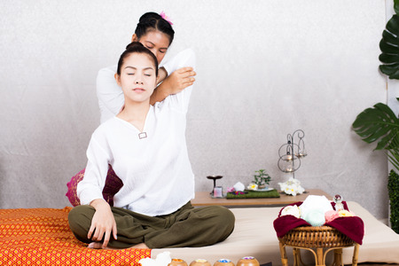 Beautiful young woman having her body with masseur in spa salon. Woman with thai massage. Woman with relax emotion.の写真素材