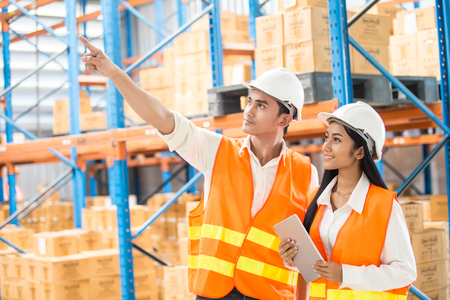 Male and Female Industrial Engineers looking to direction with attractive smiling. They Work in Industry Manufacturing Factory.