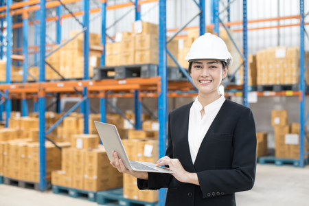 Female architect holding laptop with smiling at warehouse. People working concept.の写真素材