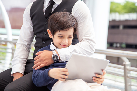 Boy using tablet with happy emotion at city. People with technology concept.の写真素材