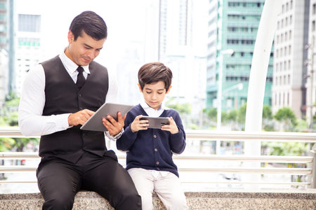 Father and Boy using Smartphone Together at Outdoor Place. People with Technology, Family, Education Concept.の写真素材