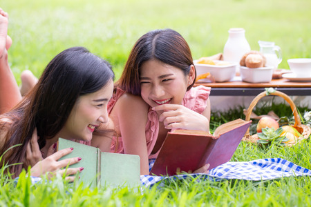 Female and friend picnic together at the public garden, Women resting at garden together in holiday....
