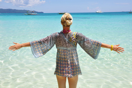 Young fashion woman on the beach in blue shirtの写真素材