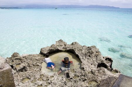 Boracay island, Philippines - August 11, 2011: two little boys are relaxing  on Boracay beach in Philippinesのeditorial素材
