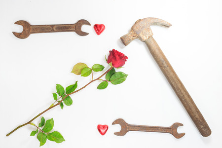 Old Rusty Hammer wrench heart and rose on white backgroundの写真素材