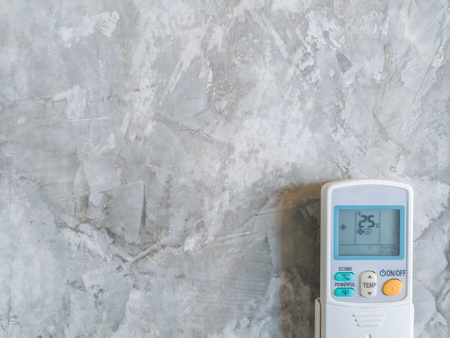 Air Condition Remote on Loft Style Wall Background with Copy Space, Minimalist Styleの写真素材