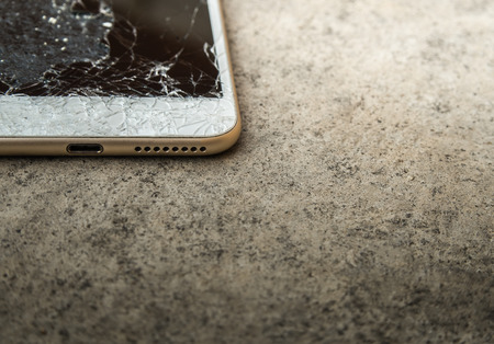 Close up of broken mobile phone or tablet droped on cement floor with copy space, High contrast