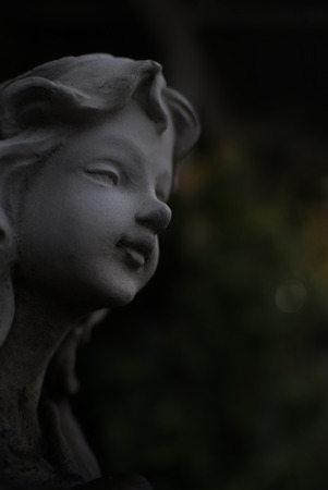 Gray angel plaster statue The garden is decorated in European style vintage statue Girl. Low key.