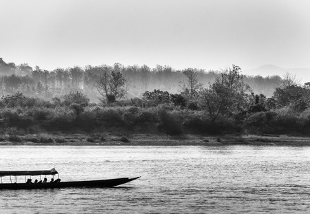 Black and white monochrome image of the boat sailing on Mekong river with forest and mountain on background
の写真素材