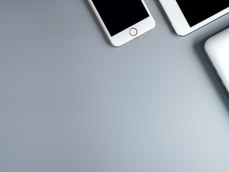 Flat lay and minimalist image of laptop, smartphone and tablet on gray background with copy spaceの写真素材