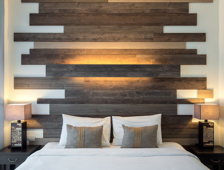 Empty double bed and lamp on wooden table on side of bed in luxury and natural style bedroom is decorated with wooden boards.
の写真素材