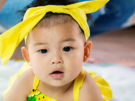 Portrait of cute short hair asia baby girl in color full wearing and face doubtの写真素材