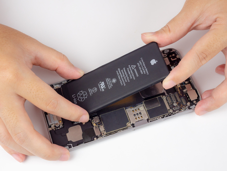 Chiang Rai, Thailand: September 13, 2018 - Close-up image of Technician hands tried to remove, take of, change or replace Apple iPhone 6 battery degenerate or damage.のeditorial素材