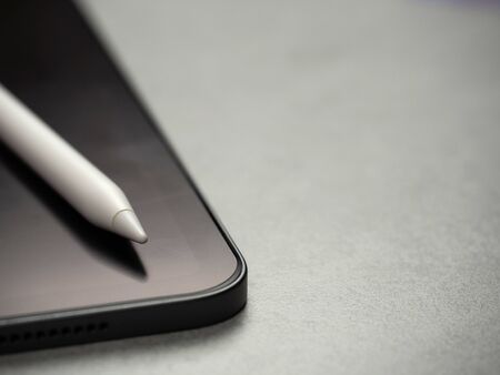 Top view image of stylus pen on black blank new luxurious tablet with copy space