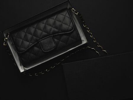 Close-up and top view of elegance women's accessories fashion black shoulder leather bag with golden chain in box.の写真素材