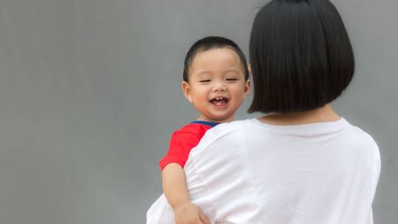 Close-up of Asian mother or babysitter holding happiness Asian toddler kid with copy space. Baby care and childhood concept.の写真素材